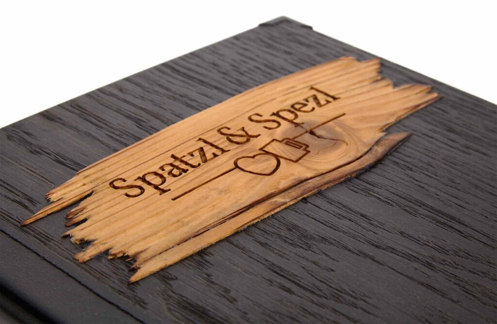 Speisekarte aus Holz in Schwarz mit Klemmrücken aus Medici in Schwarz und Altholzstreifen auf der Vorderseite